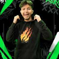 Person wearing a black hoodie with a colorful design, standing against a black background with green and white abstract elements.